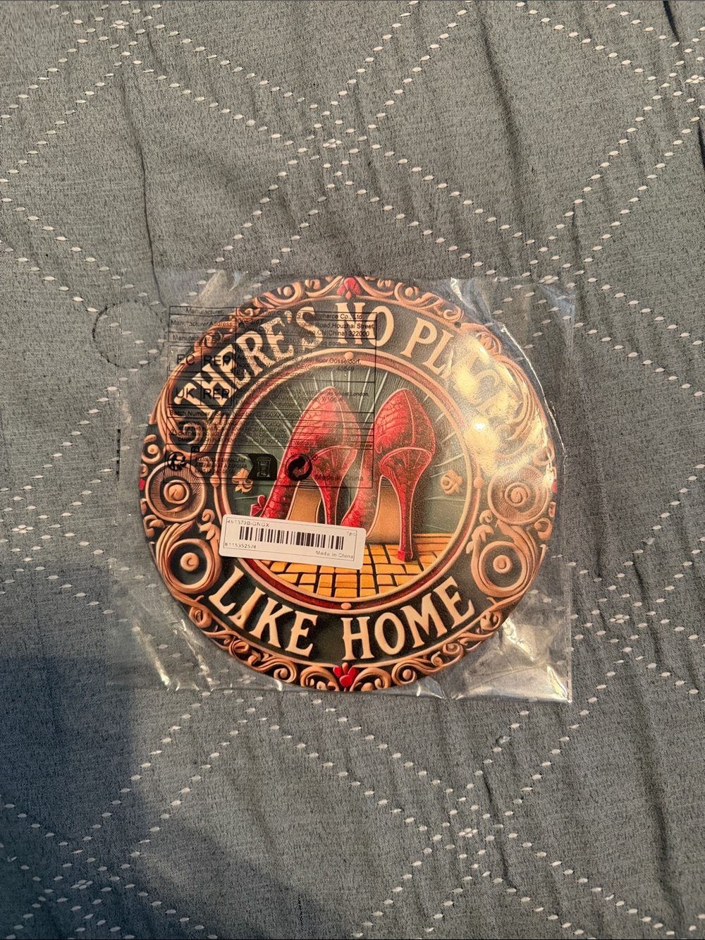 Round Decorative Sign 'There's No Place Like Home' with Red Heels